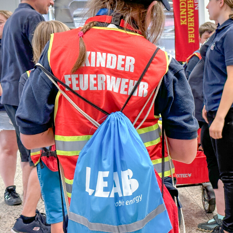 Kind von hinten mit Feuerwehrweste und Turnbeutel von LEAB.