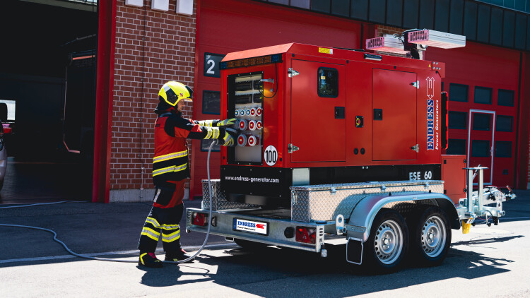 Ein Lichtmastwagen der Firma Endress und ein Mitarbeiter der Feuerwehr.