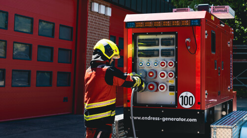 Ein Mitarbeiter der Feuerwehr schließt ein Kabel an einen Lichtmast der Firma Endress an.