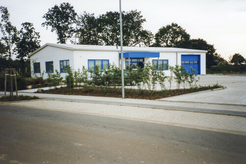 Weißes Gebäude mit blauem Garagentor.